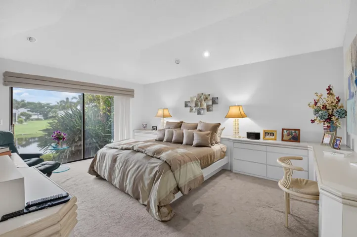 Expansive sliding glass doors, built-in recessed lighting, and soft carpeting