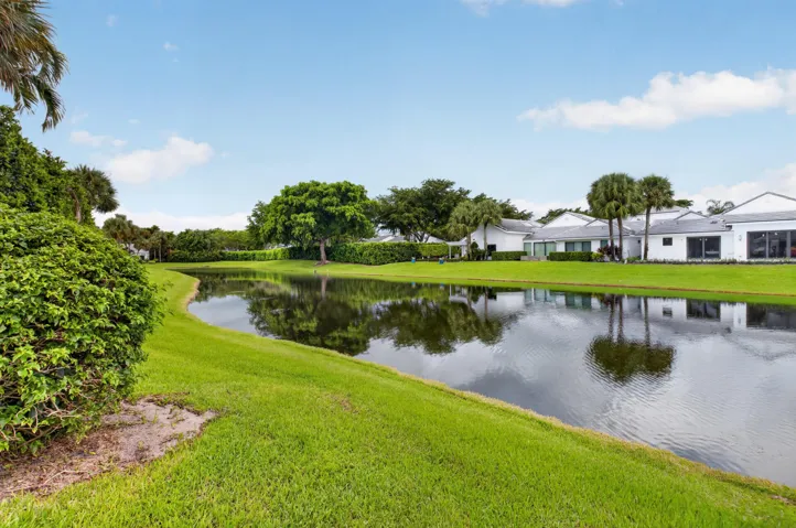 Waterfront property featuring lush green lawns and established landscaping
