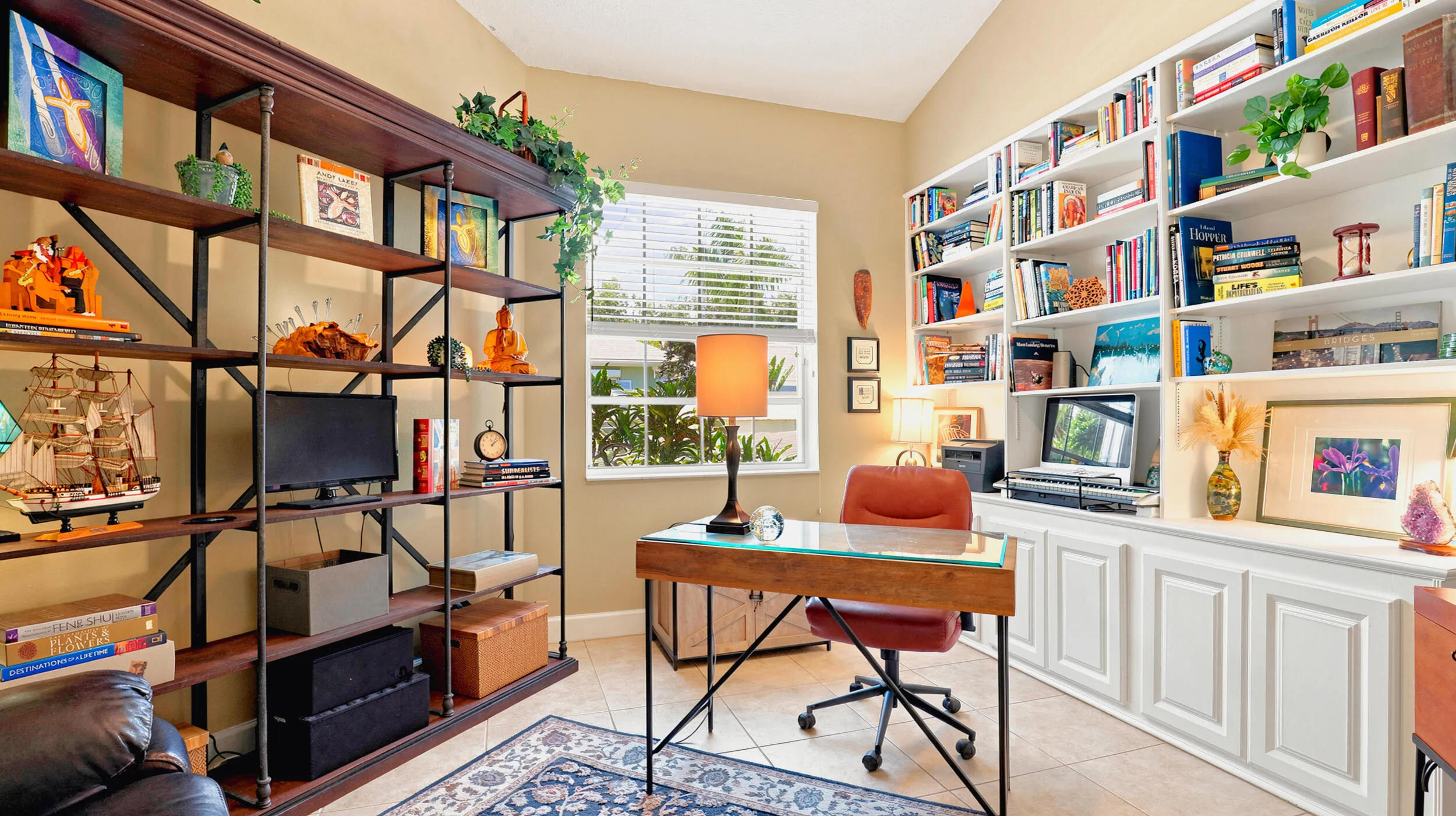 Dedicated office with extensive built-in shelving, cabinetry, workspace, and natural light.