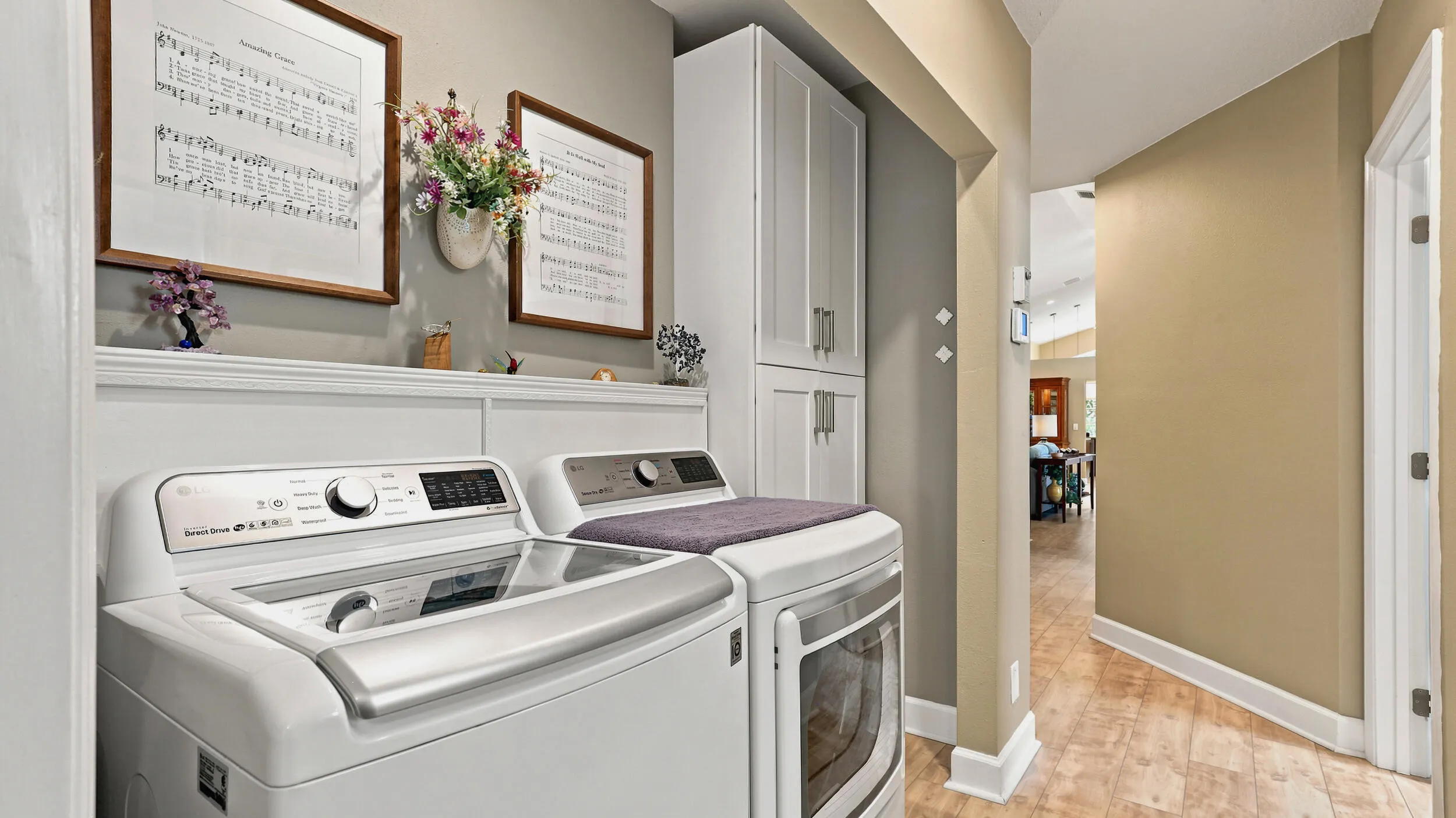 Dedicated laundry area with full-size washer and dryer, cabinetry, and convenient storage.
