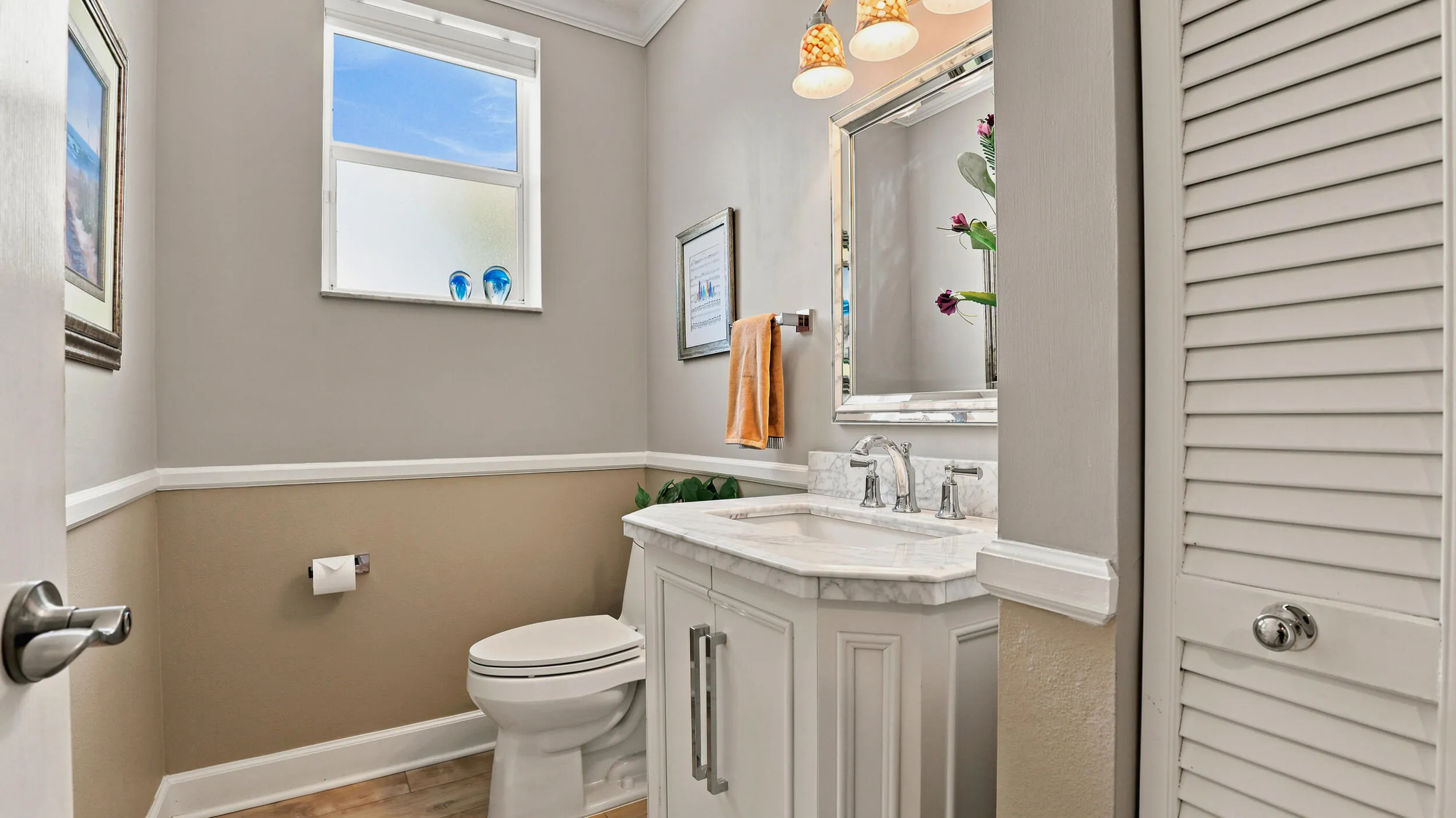 Convenient half bath with vanity, decorative lighting, and neutral finishes.