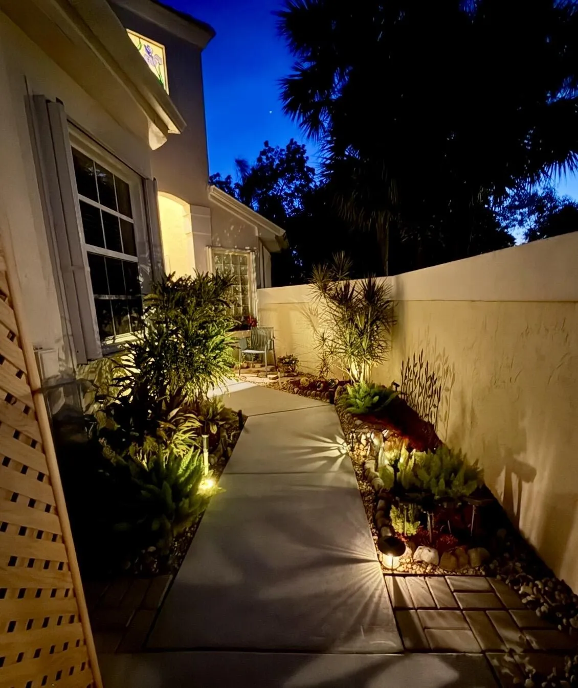 Illuminated walkway creating a warm and inviting approach to the home.