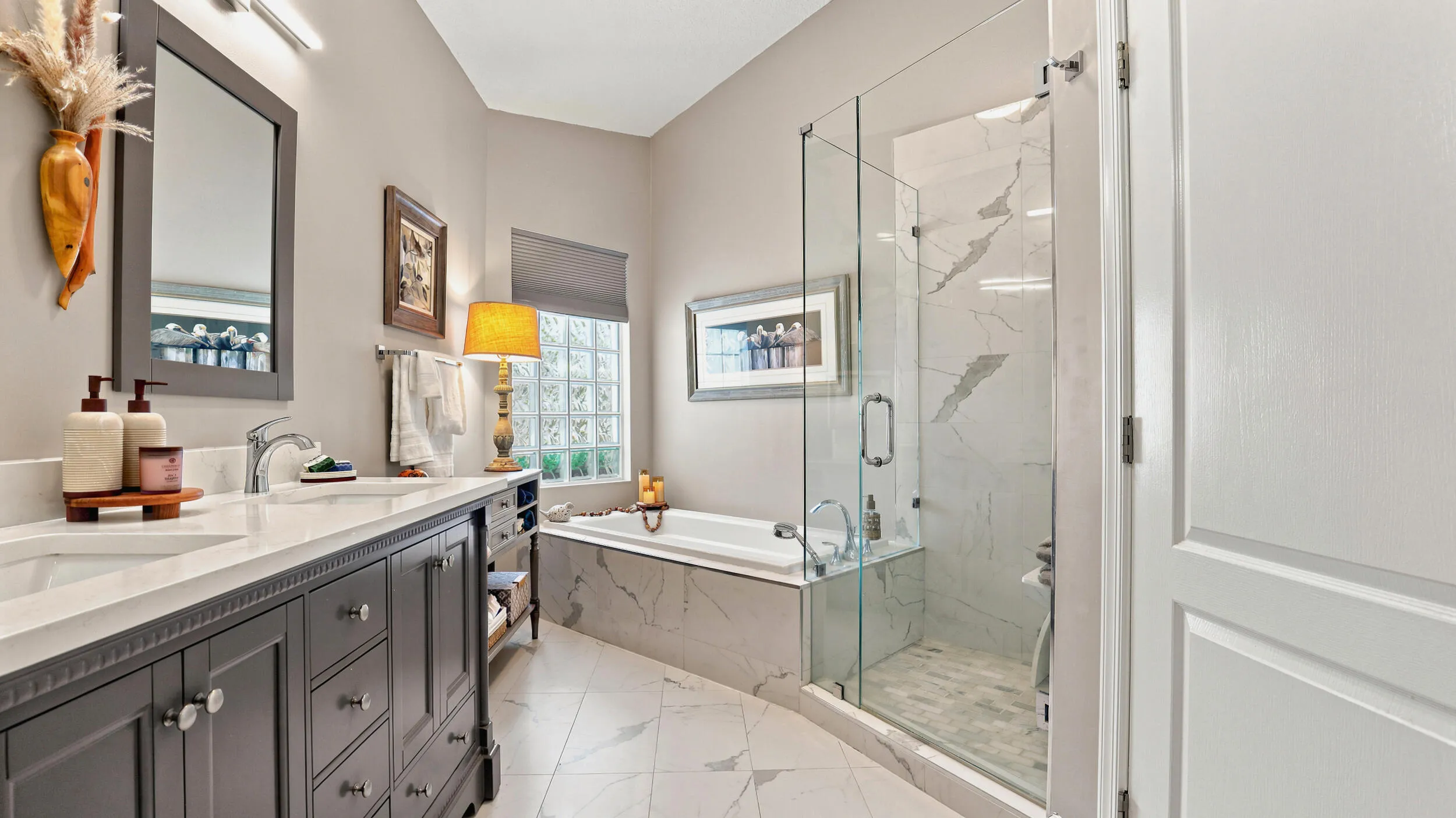 Dual-sink vanity with generous counter space and a separate glass-enclosed shower.