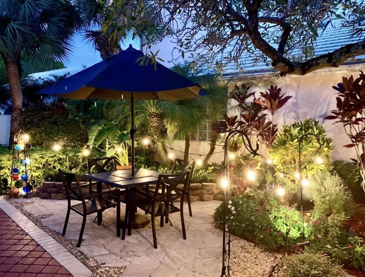 Beautifully illuminated garden patio offering a relaxing setting for outdoor dining and entertaining.