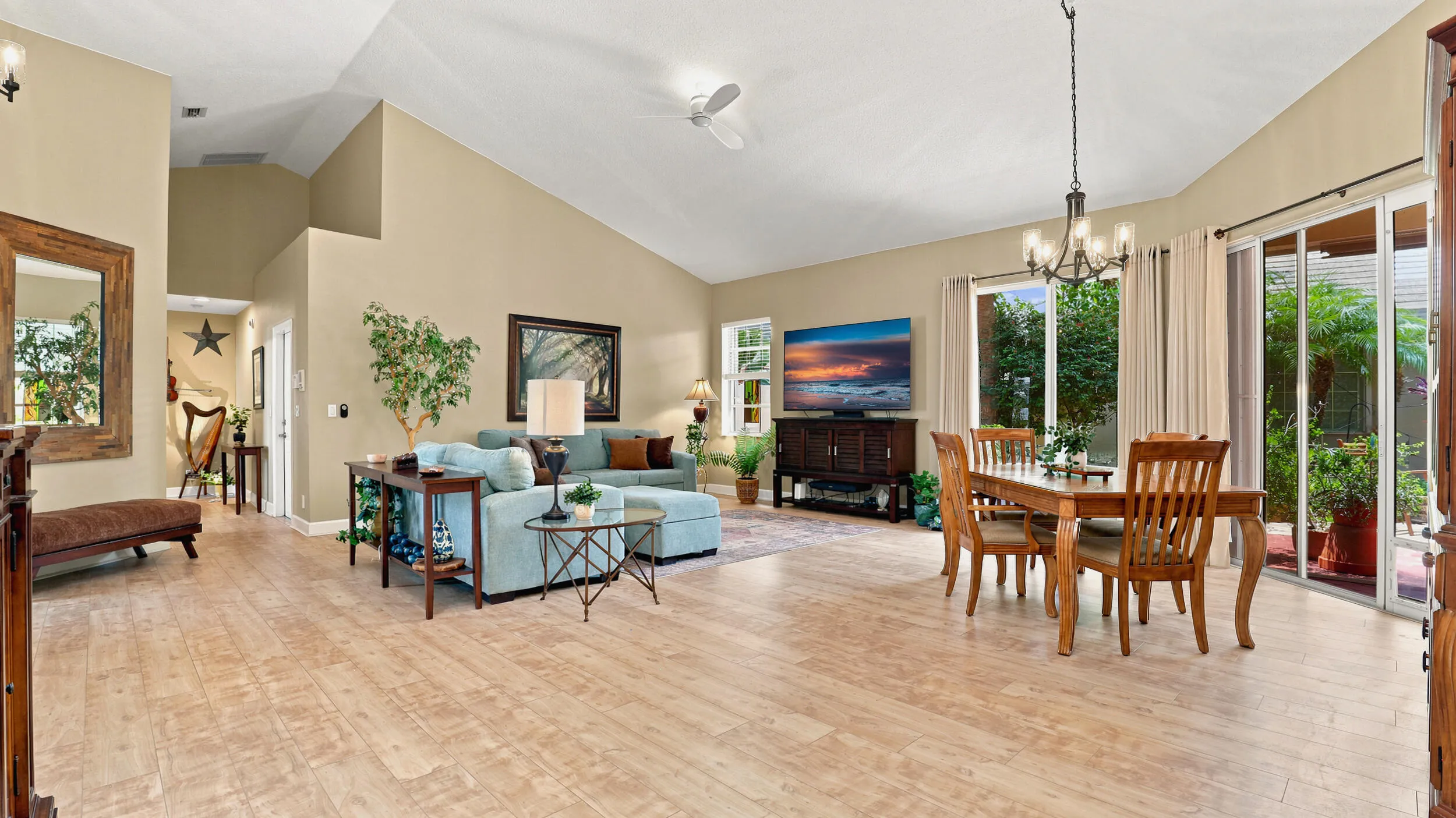 Open living and dining space with vaulted ceilings and direct access to the outdoor area.