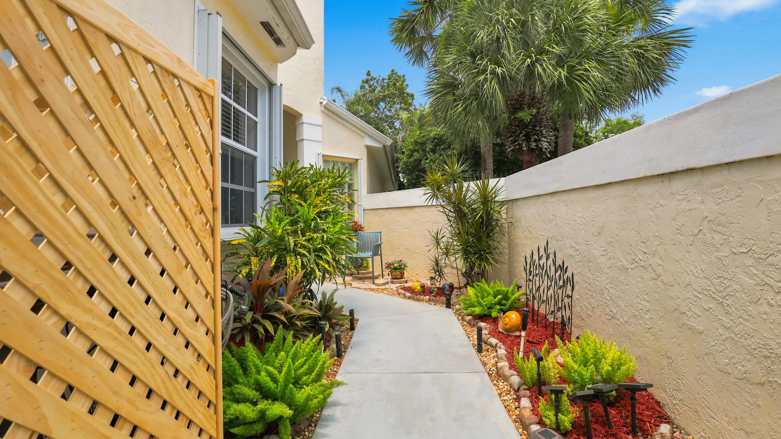Garden-lined walkway featuring colorful plantings and a private, welcoming setting.