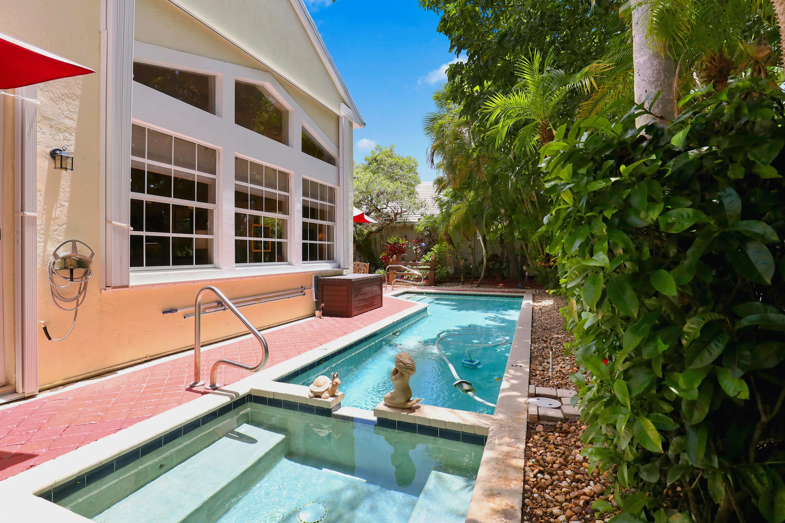 Private pool and spa area surrounded by lush tropical landscaping and patio space.