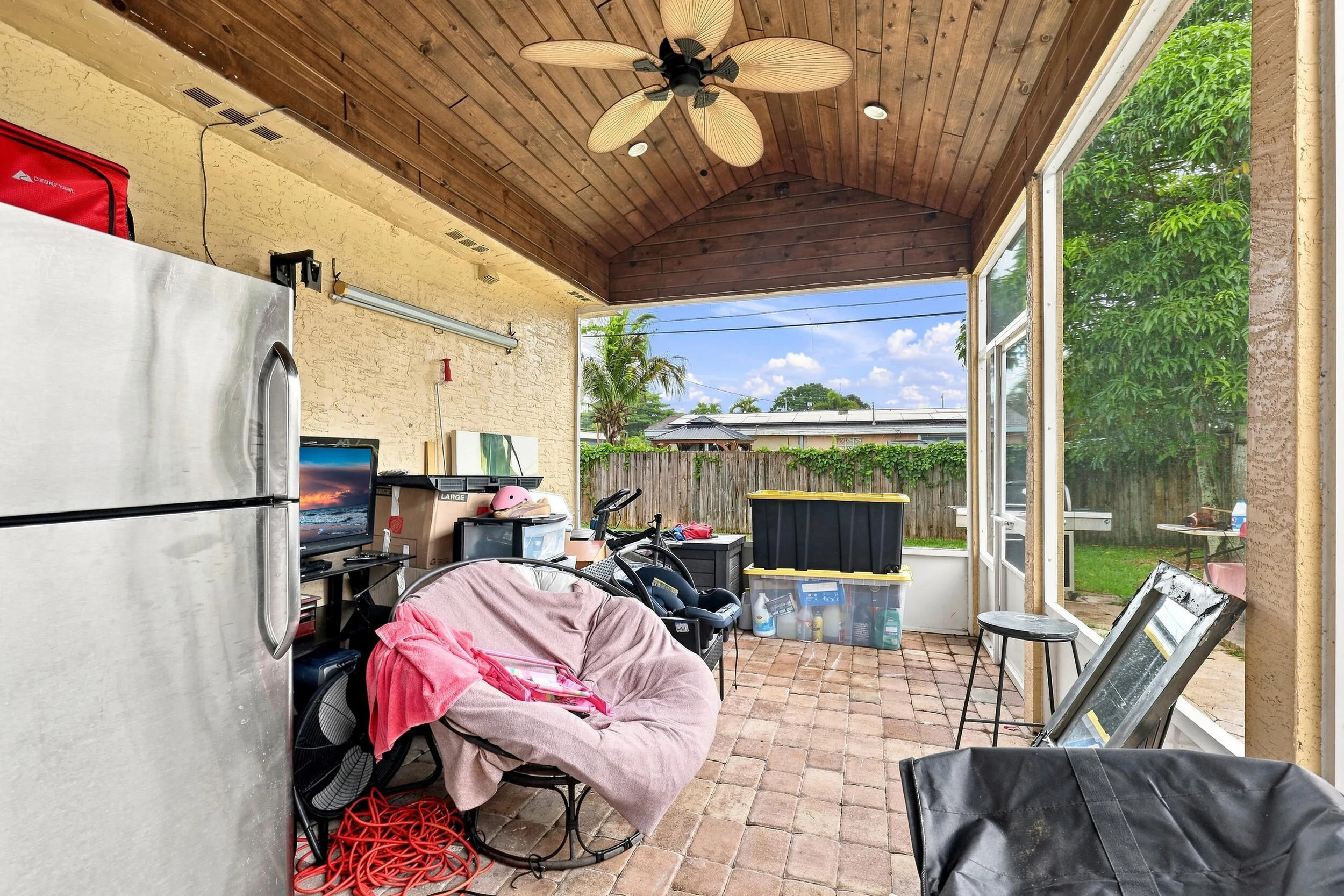 Additional patio view featuring a wood ceiling, ceiling fan, and access to the backyard.