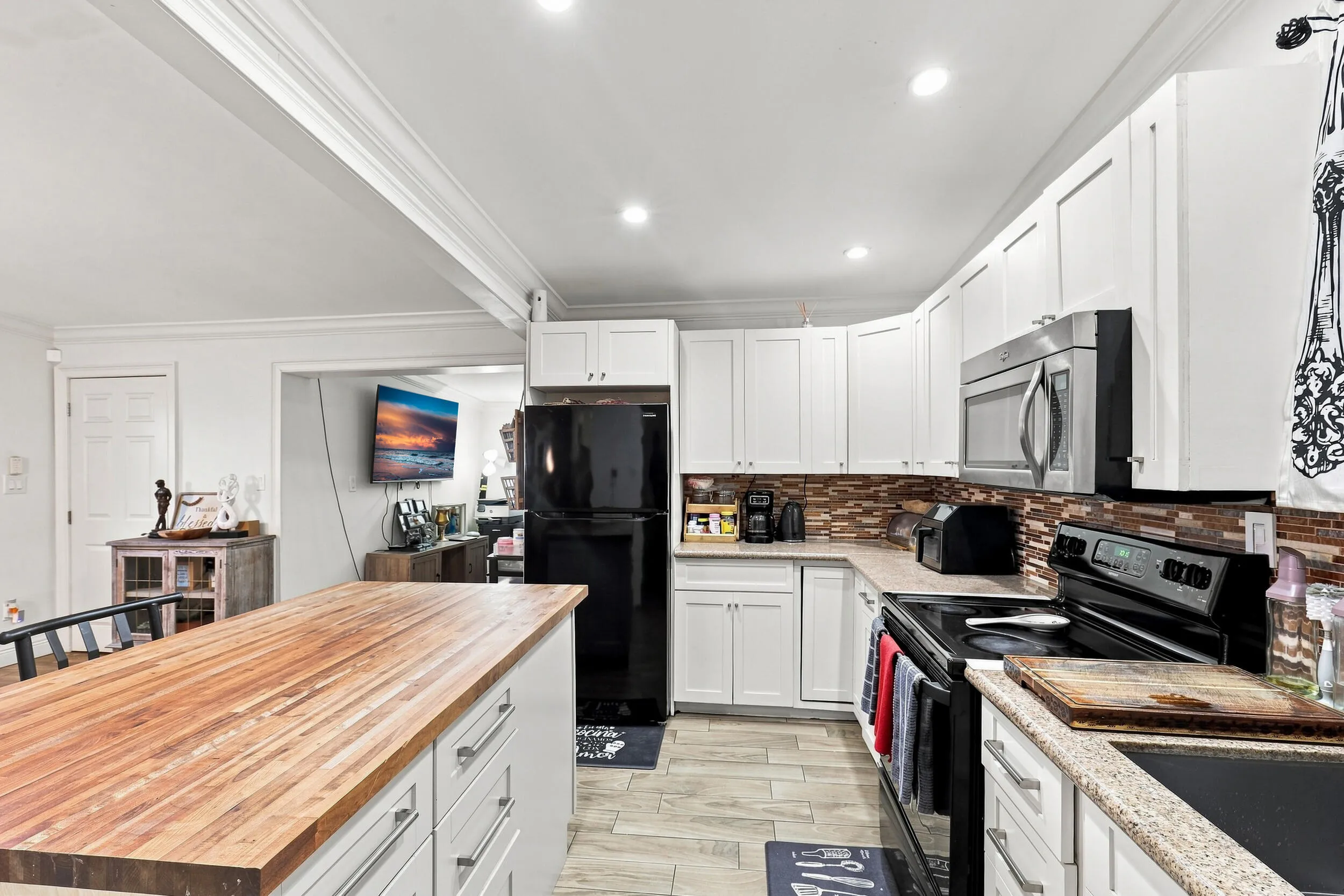 Additional kitchen view showcasing white cabinetry, ample counter space, and the large center island.