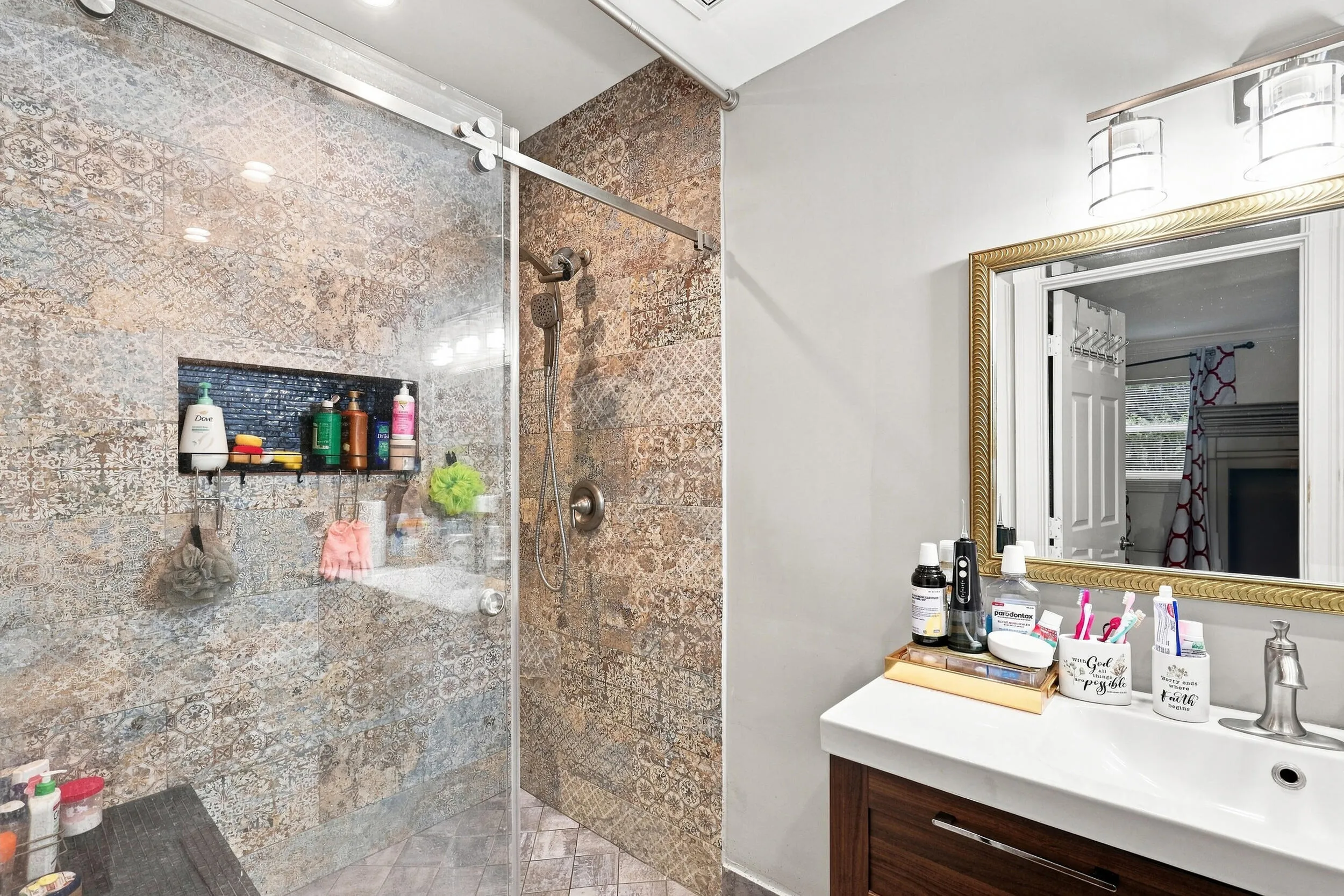 Bathroom featuring a large vanity and tiled walk-in shower with glass enclosure.