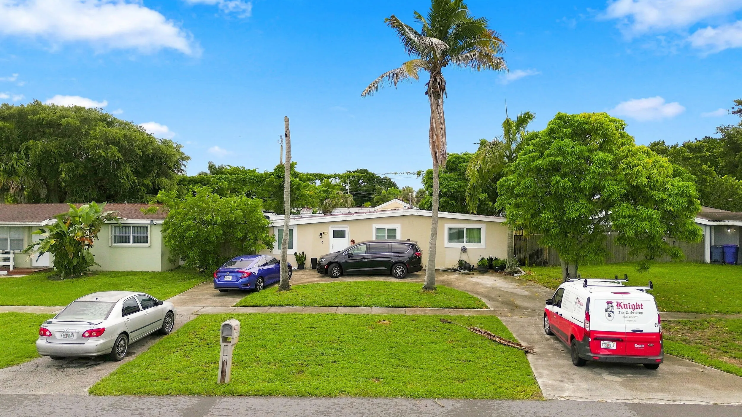 Additional elevated view showcasing the home, front lawn, driveway, and mature landscaping.