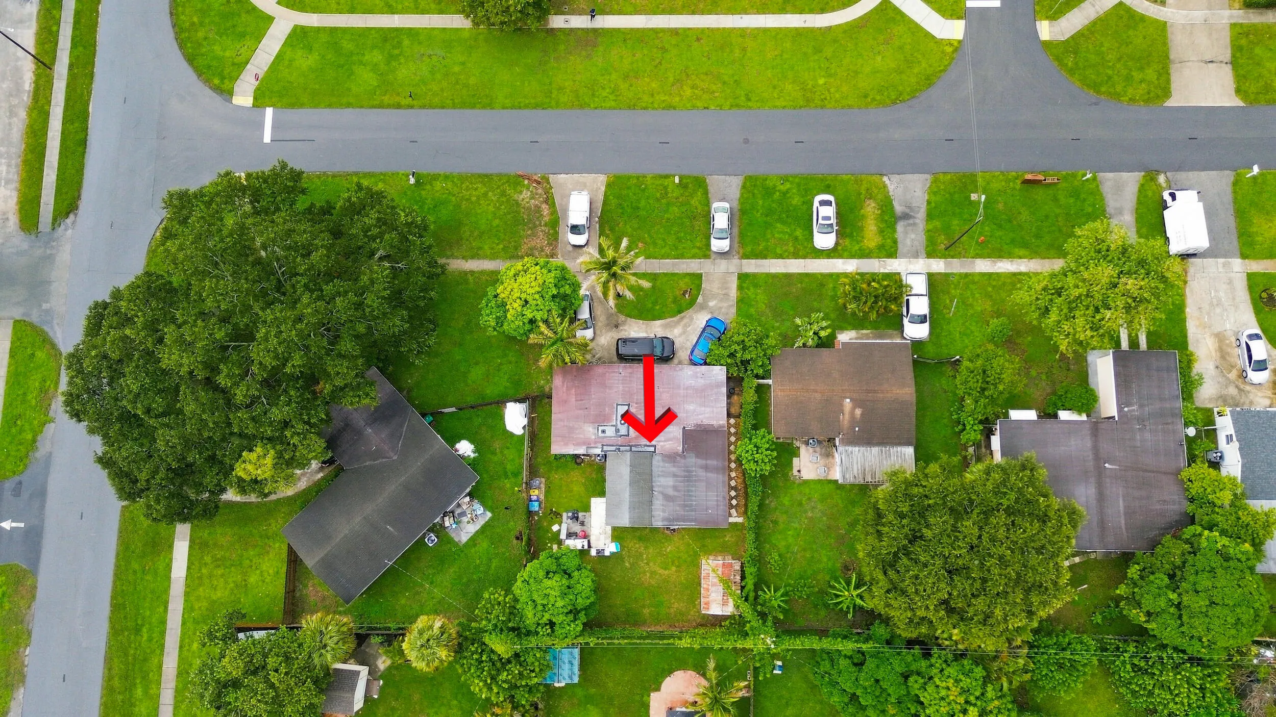 Wider overhead perspective showcasing the property boundaries and its setting within the surrounding neighborhood.