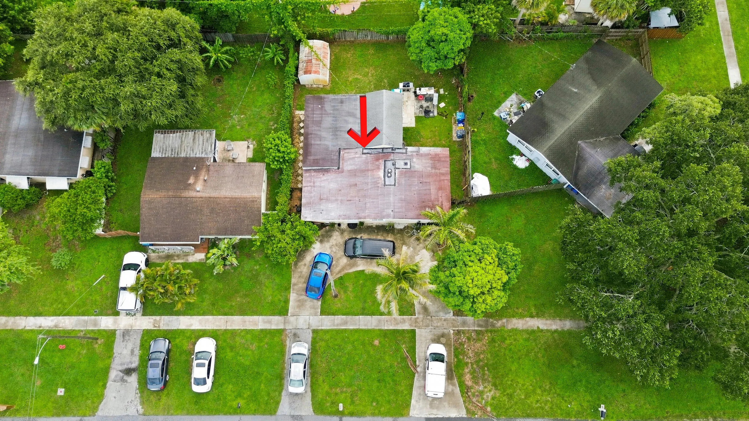 Overhead aerial view highlighting the home, lot, driveway, and surrounding properties.