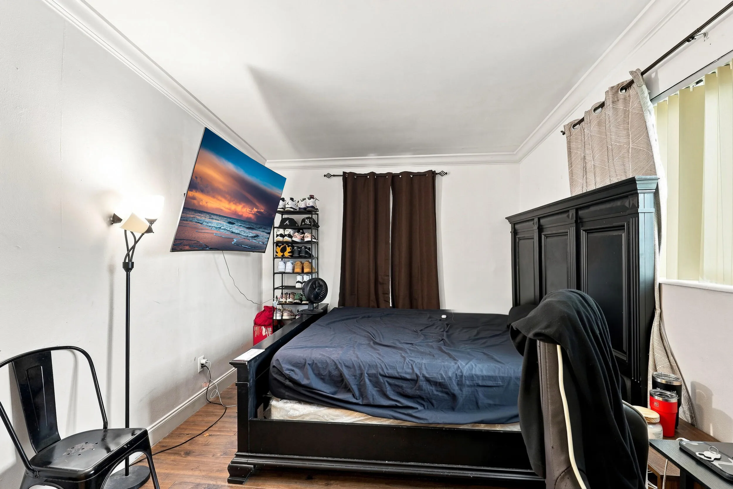 Bright secondary bedroom with wood-look flooring and neutral finishes.