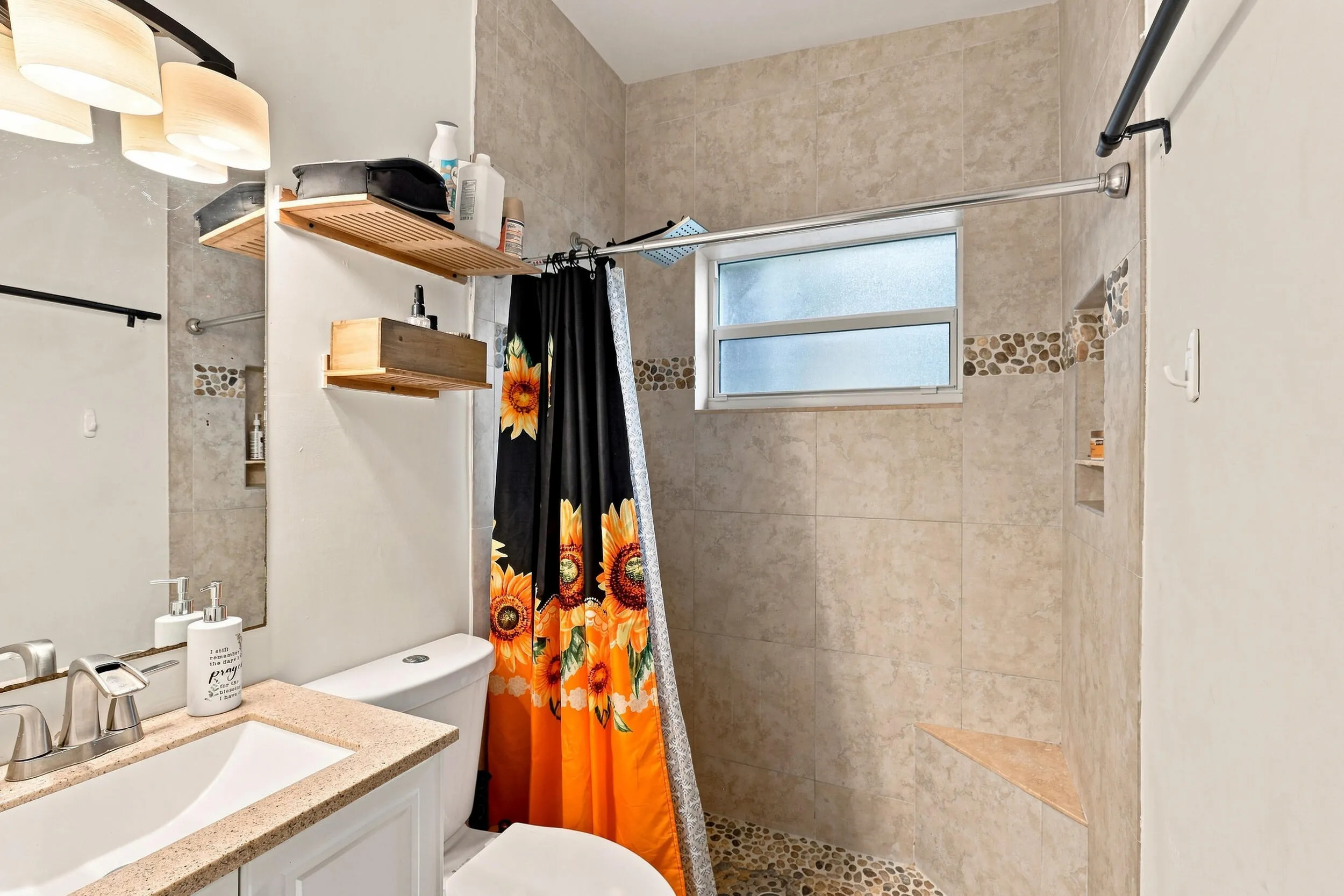 Full bathroom featuring a vanity, tub and shower combination, and natural light.