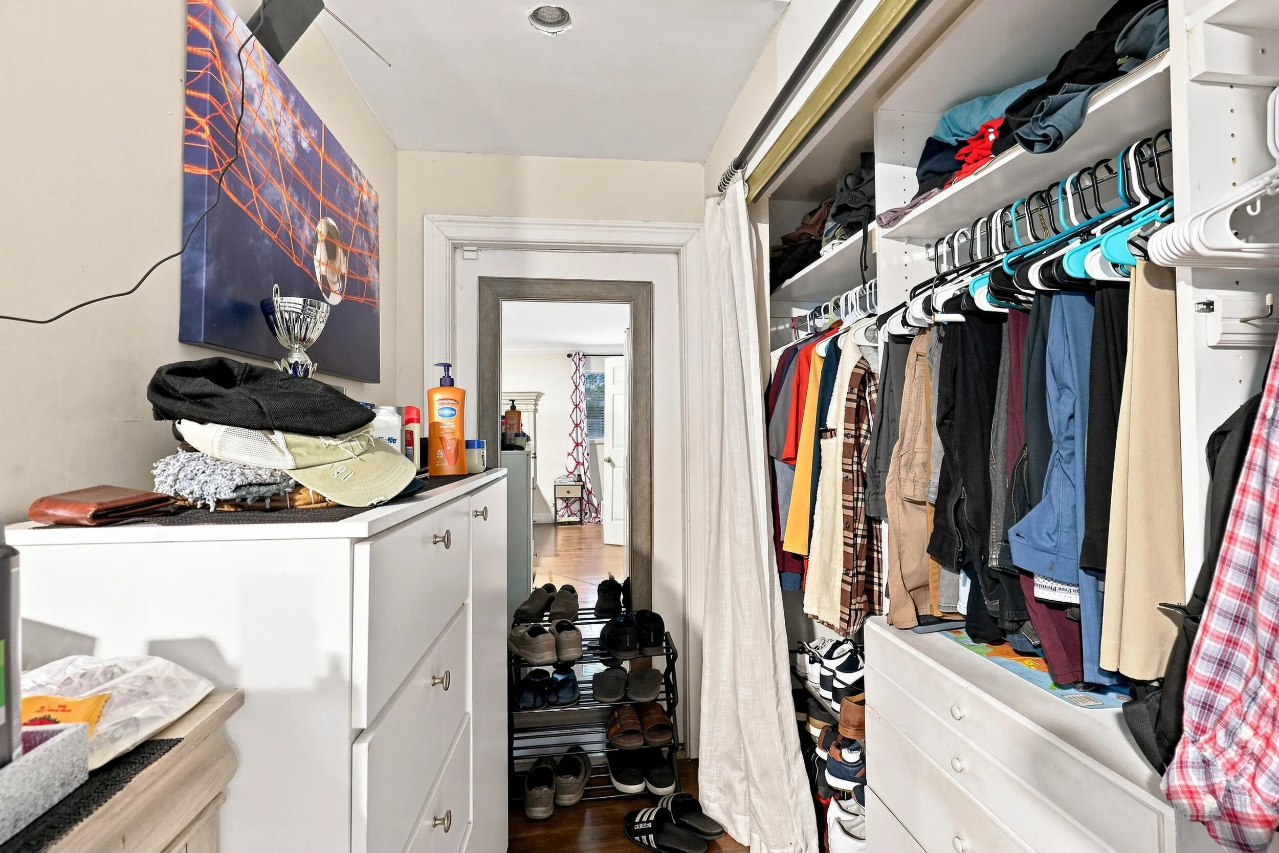 Additional view of the walk-in closet with shelving, hanging space, and convenient access to the bedroom.