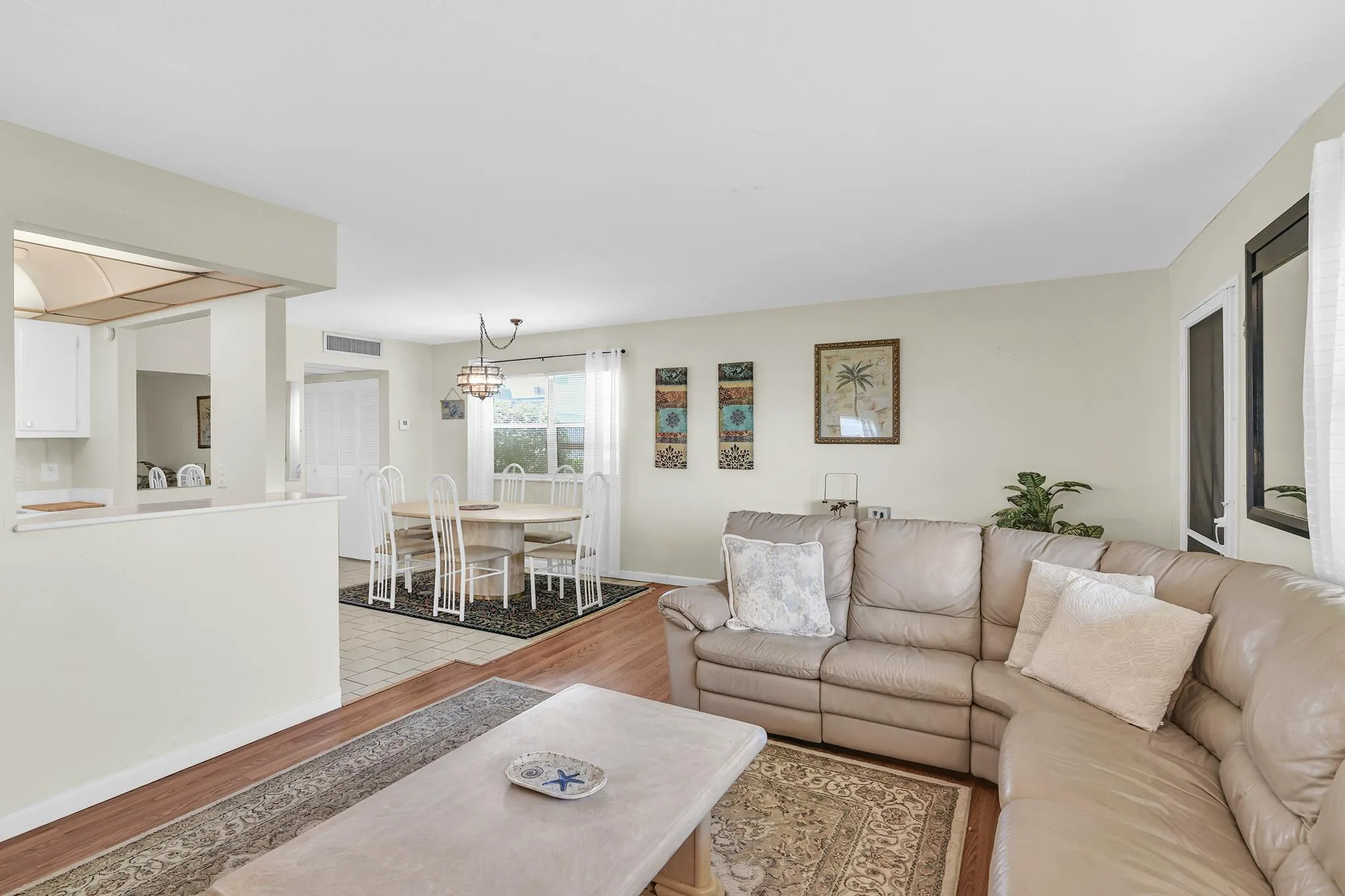 Open-concept living area featuring wood-finish flooring, light neutral wall tones, and recessed lighting