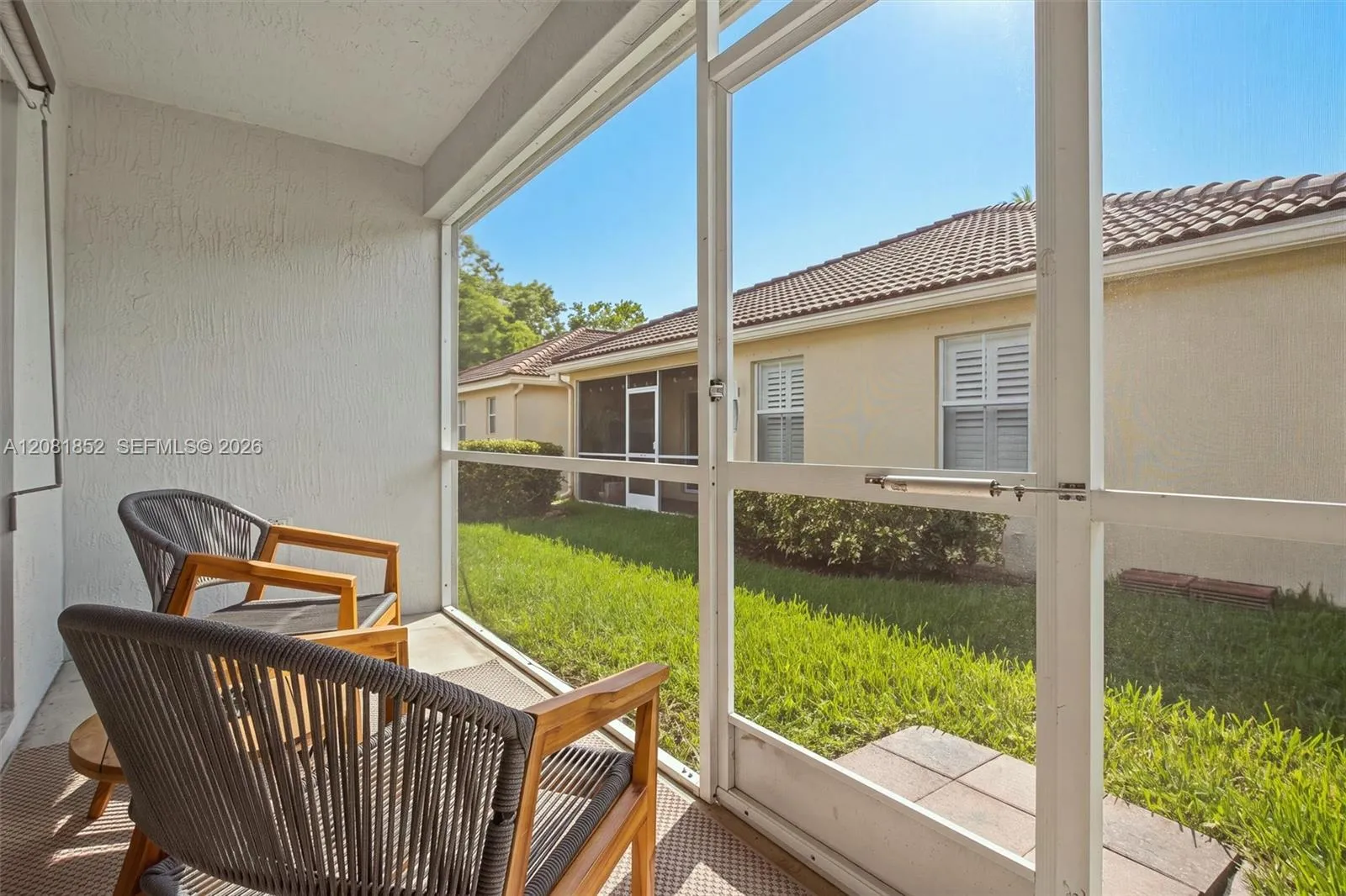Tranquil screened patio overlooking the lush green backyard.