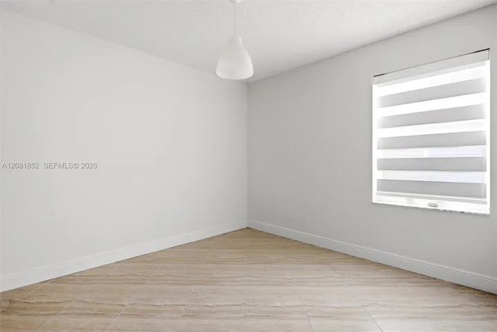 Bright secondary bedroom offering flexible space for guests or a home office.