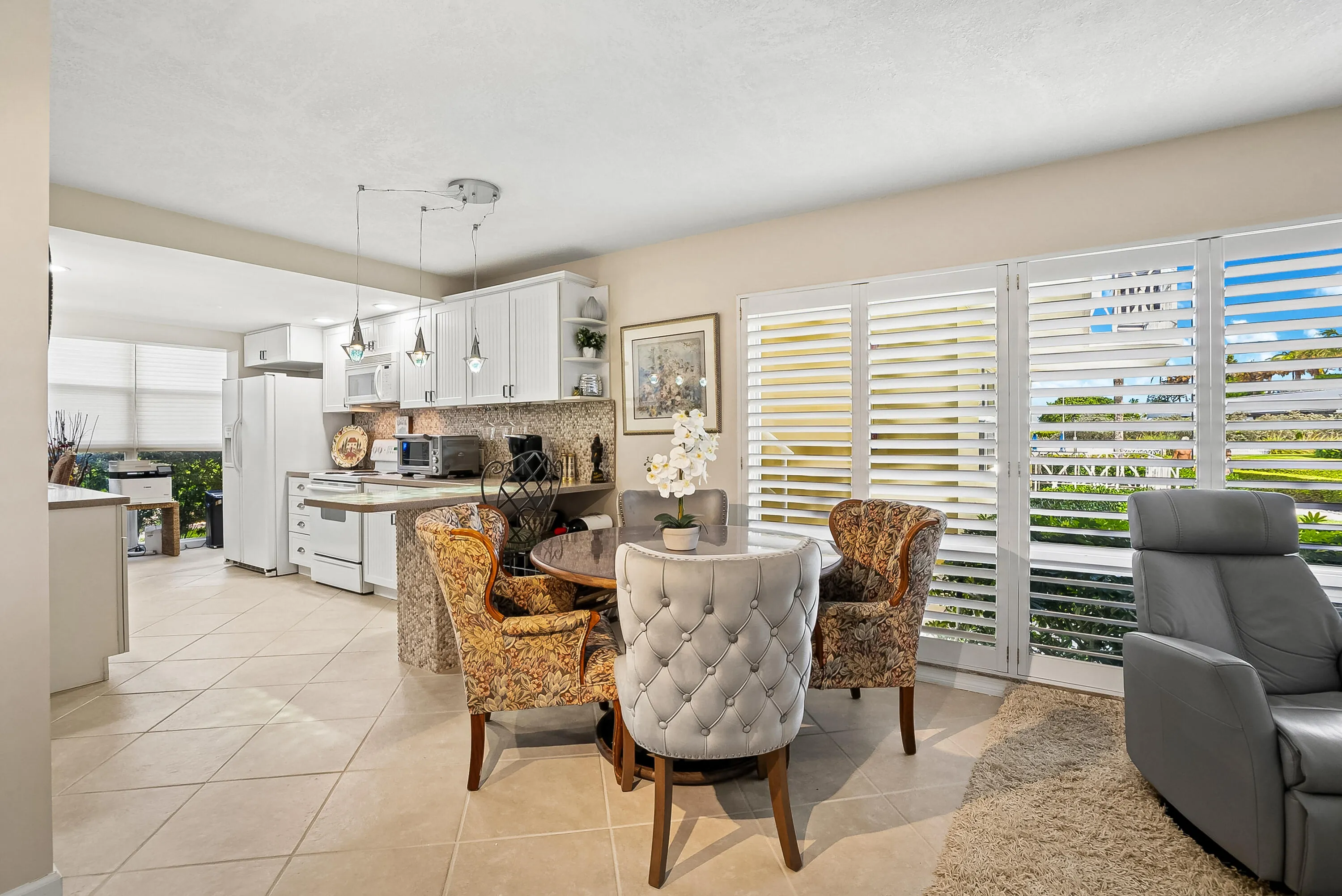 Living room and dining area surrounded by plantation shudders.