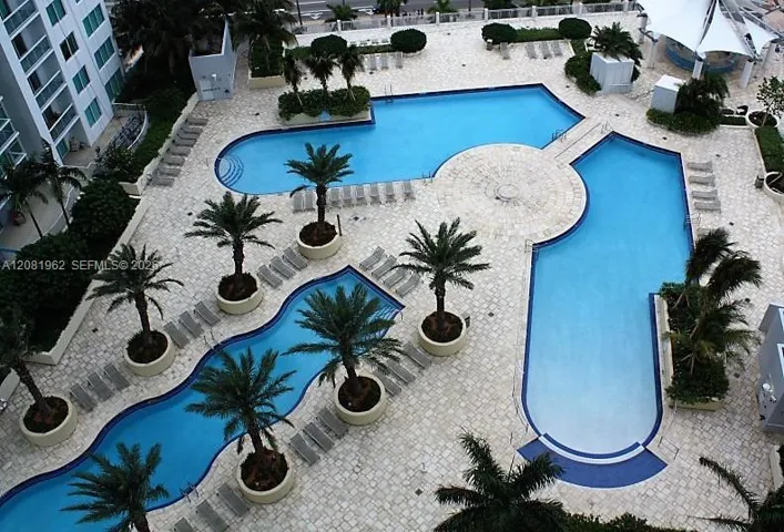 Amazing pool area with several spaces to entertain; daybeds, chairs, tiki bar, spa, gym, game room.