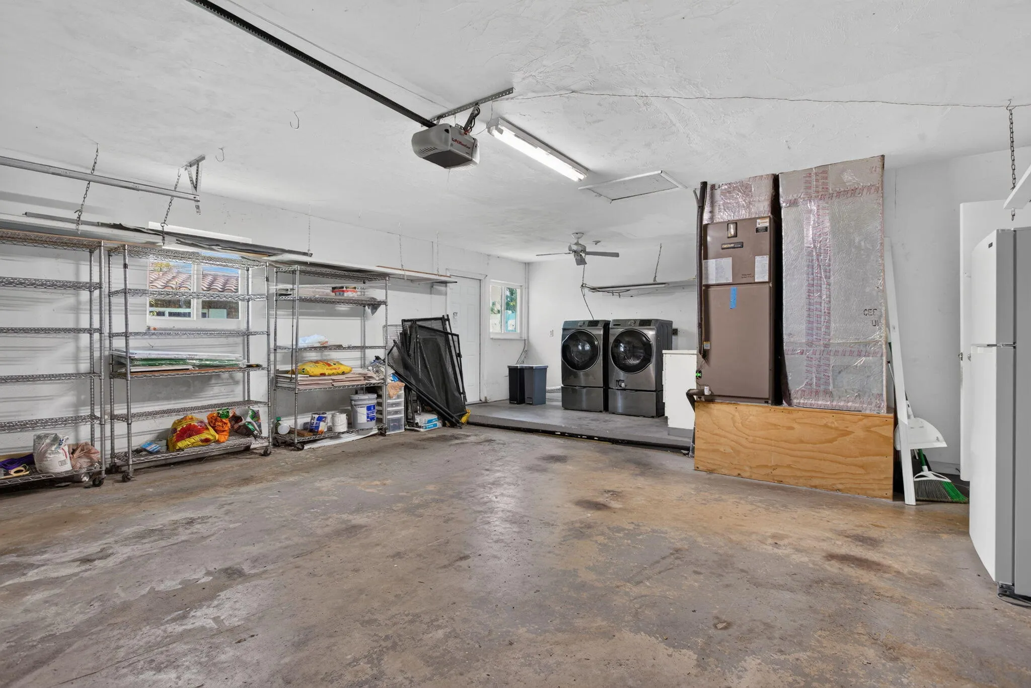 Concrete flooring, ceiling-mounted lighting, and a ceiling fan