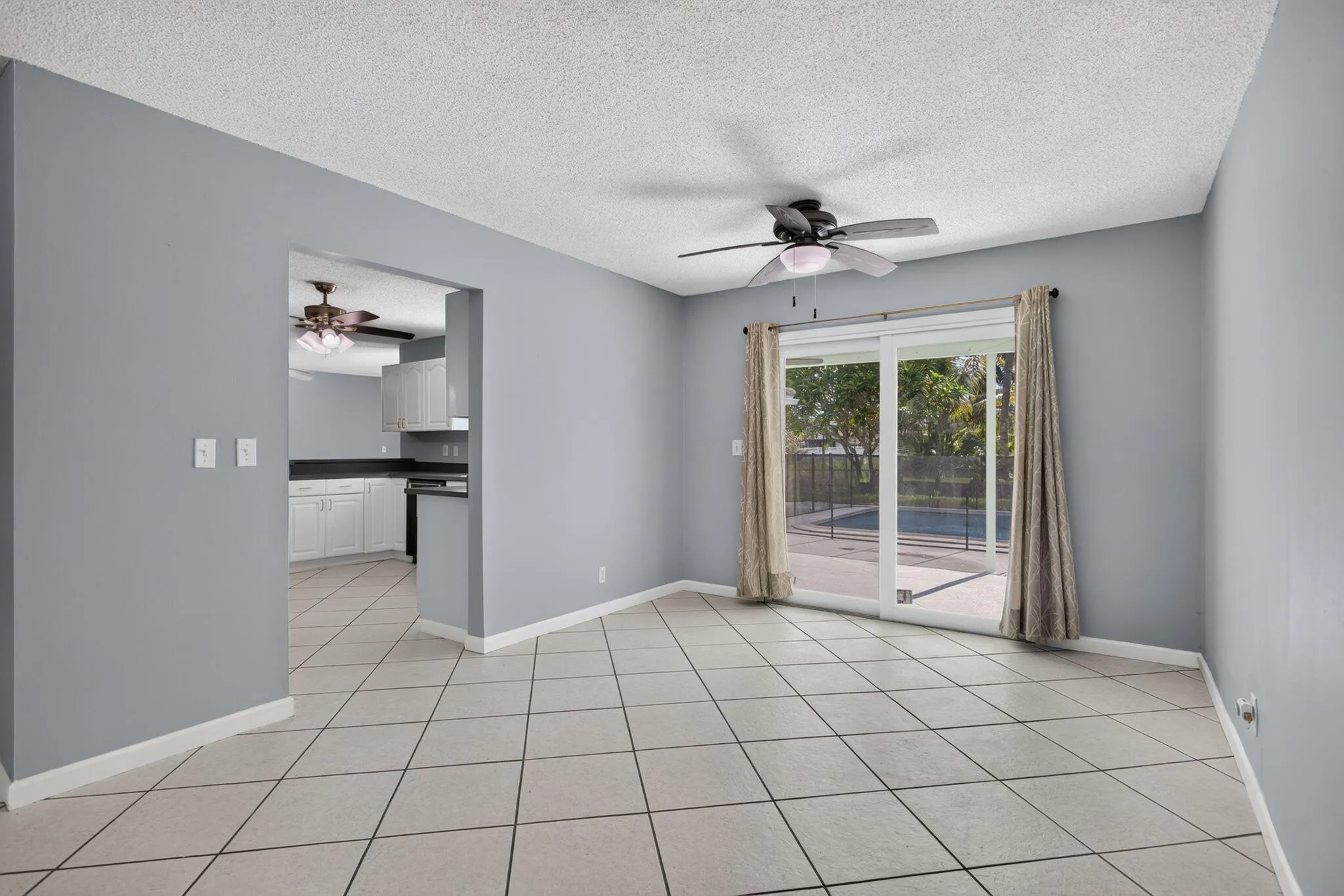 Tiled flooring, sliding glass doors, and a ceiling fan