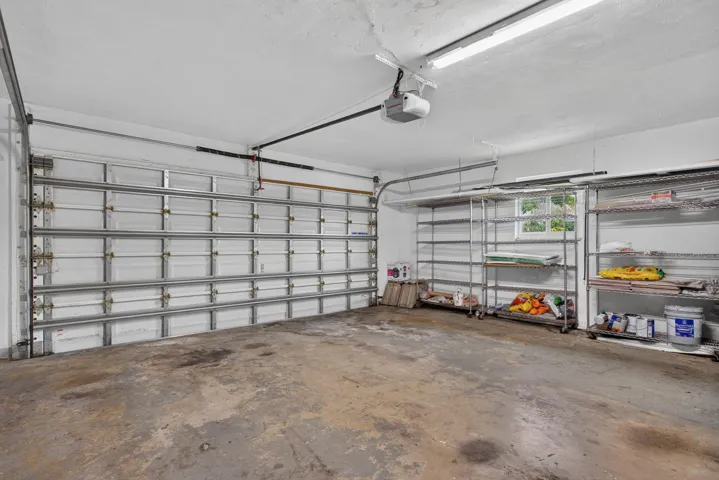 Garage with an overhead door, concrete flooring, and built-in shelving