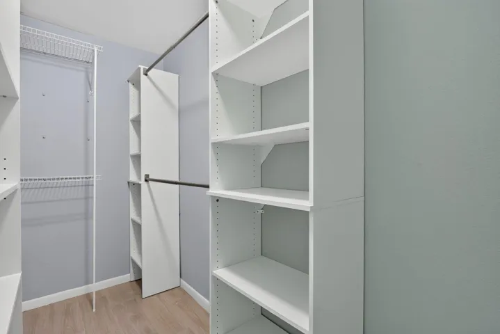 Built-in shelving systems, multiple hanging rods, wire shelving, and wood-finish flooring
