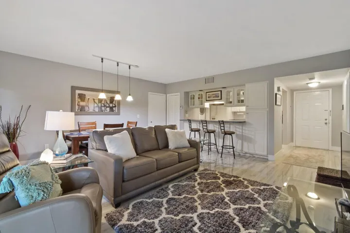Open-concept living area featuring a dining space, breakfast bar, and track lighting
