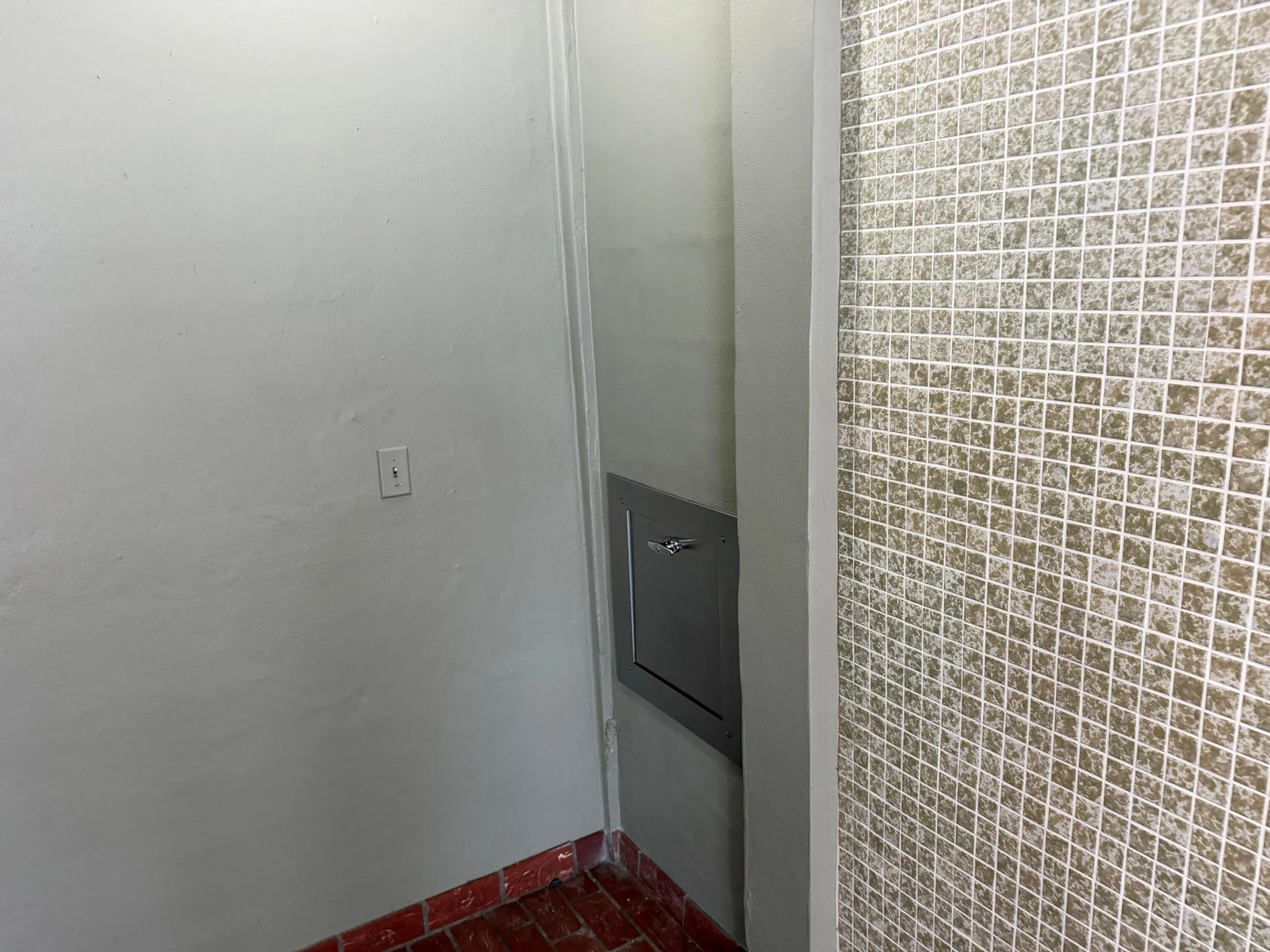 Trash chute next to elevator