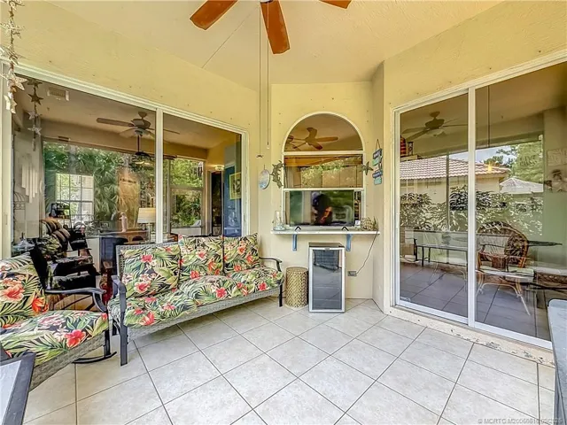 PASS THROUGH FROM KITCHEN TO SCREENED PATIO WITH FAN AND ALL TILED. THE SLIDER TO THE RIGHT IS THE KITCHEN AREA AND THE ONE TO THE LEFT IS THE LIVING AREA AND DINING. VERY PRIVE IN BACK WITH A EXTENDED PAVER PATIO OUTSIDE FOR THE GRILL AND SITTING AREA.