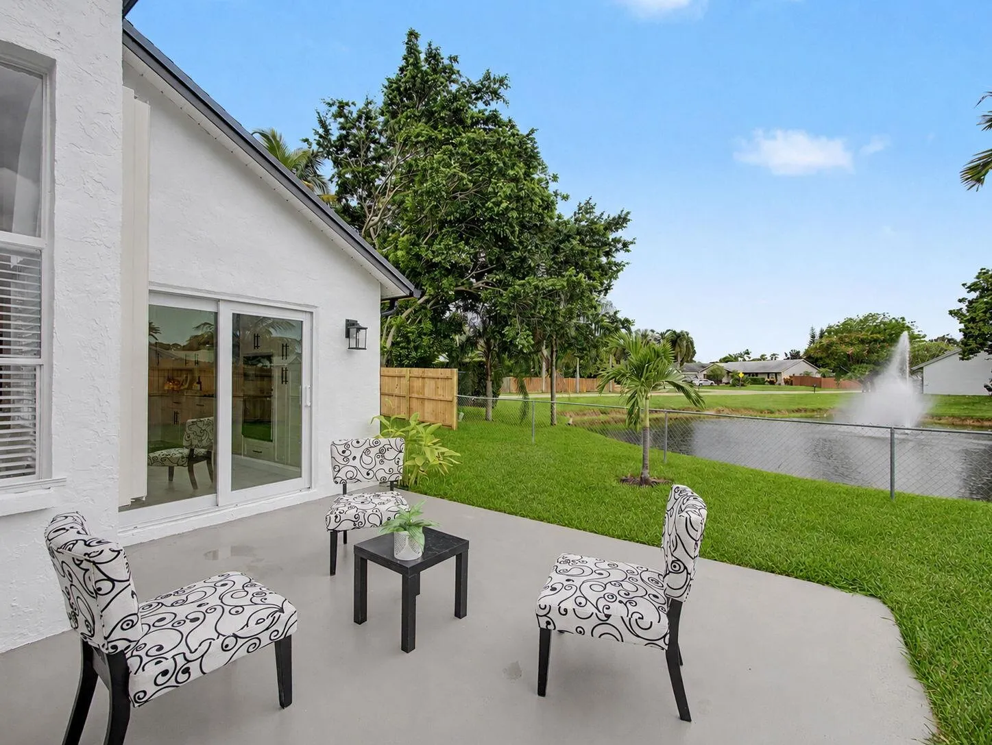 Concrete patio with a sliding glass door and exterior lighting