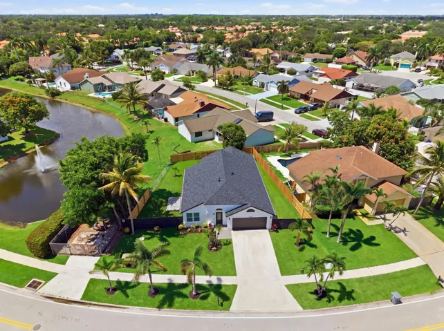 Single-story residence with a dark shingle roof, attached two-car garage, and a concrete driveway