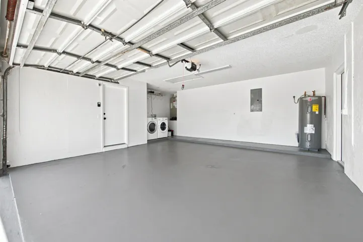 Spacious garage with light gray flooring and a white overhead garage door