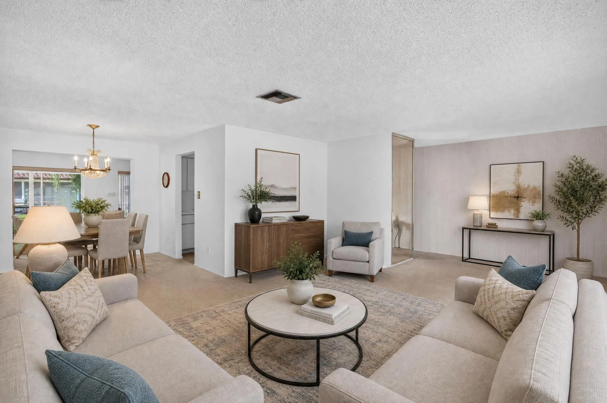 Open-concept living area with carpet flooring and light-toned walls