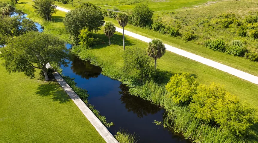 Sunlit Aerial Canal Through Green Parkla