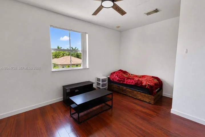 1st Master Bedroom with laminated flooring, simple layout, walking closet, and direct access to a bright vanity area. Functional space with neutral finishes.
