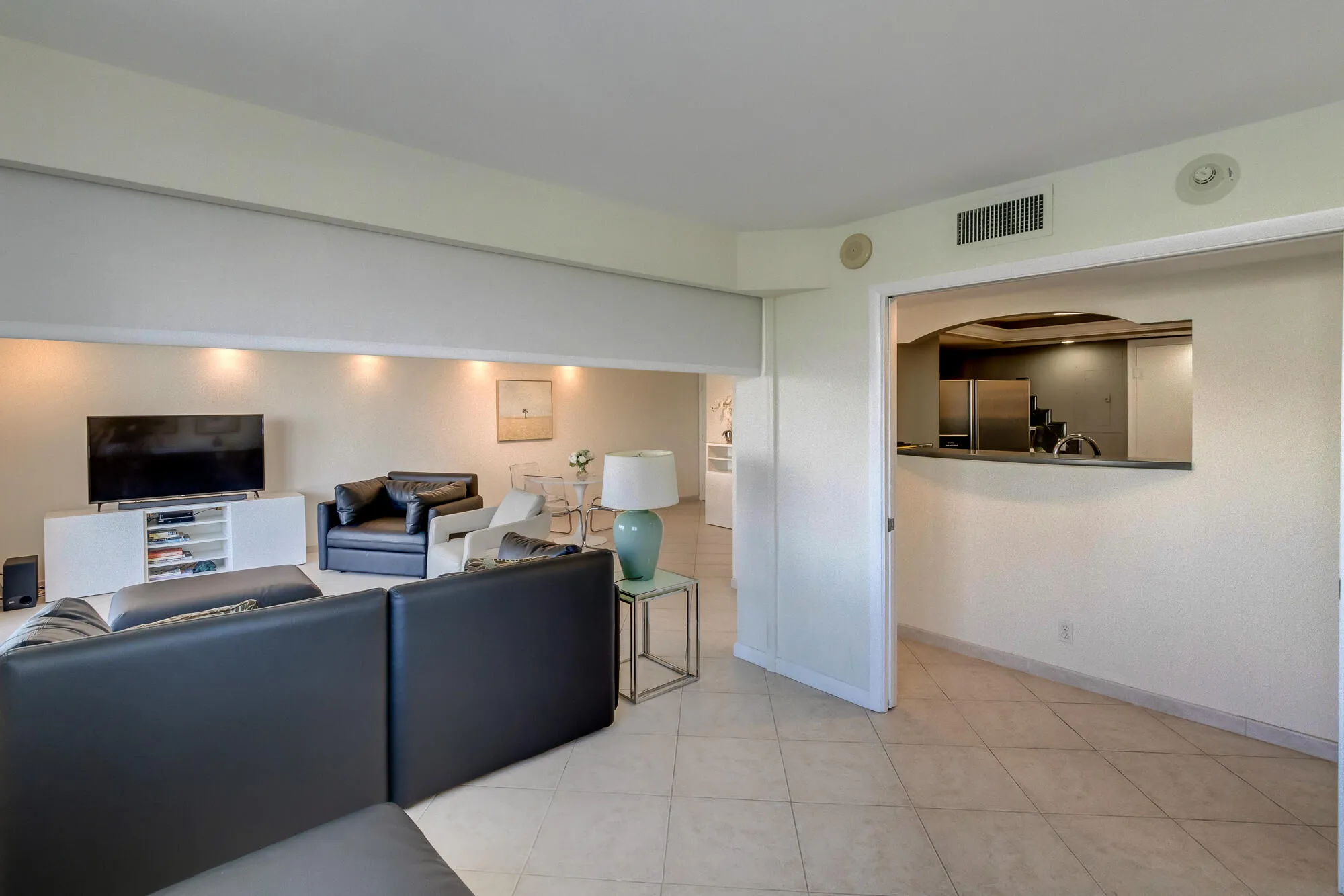 Recessed lighting, tiled flooring, built-in media console, pass-through window, and stainless steel appliances