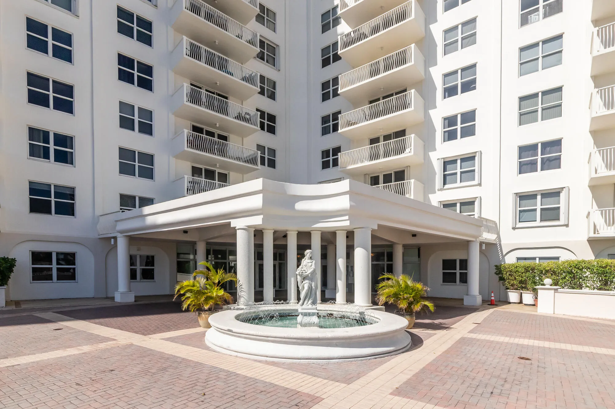 Building entrance with a portico, four columns, and a circular fountain