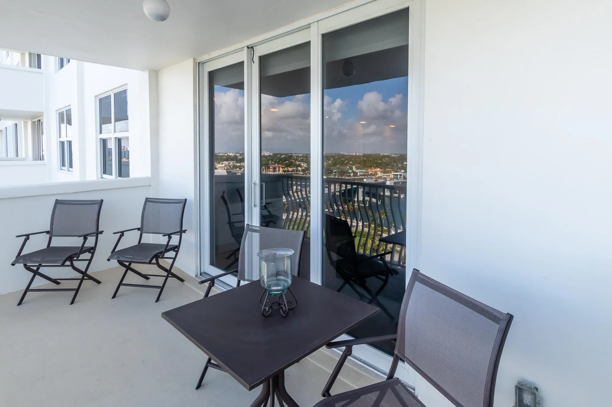 Balcony with concrete flooring, white stucco walls, and a sliding glass door