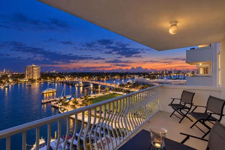 Balcony with a decorative metal railing, a water channel, and a cityscape