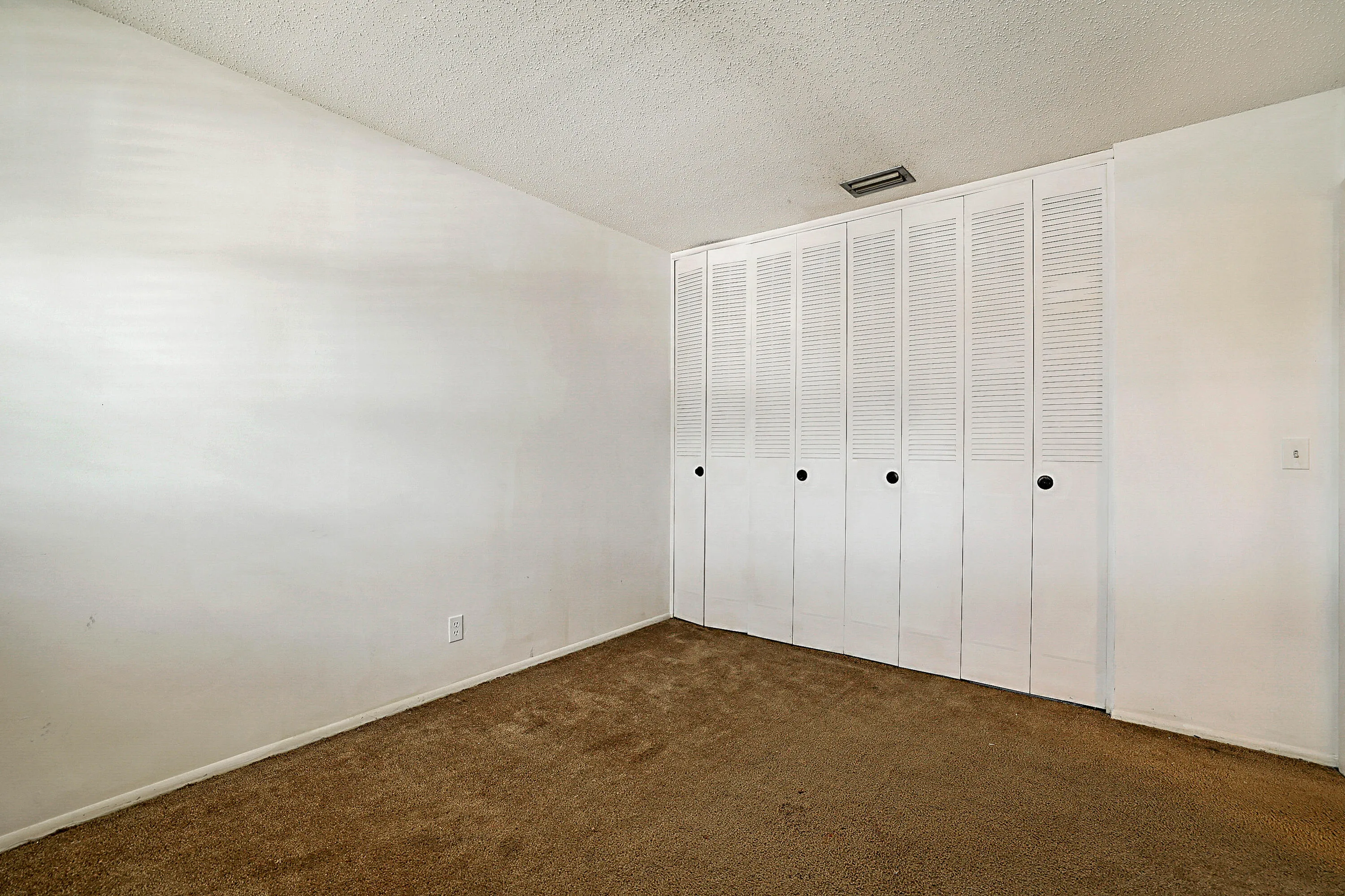 White walls with textured ceiling and brown carpet