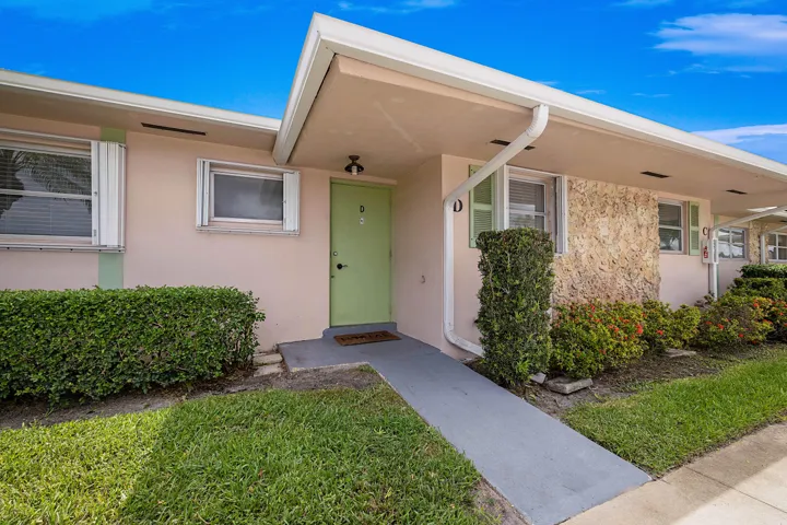 Light-toned exterior with a light green entry door