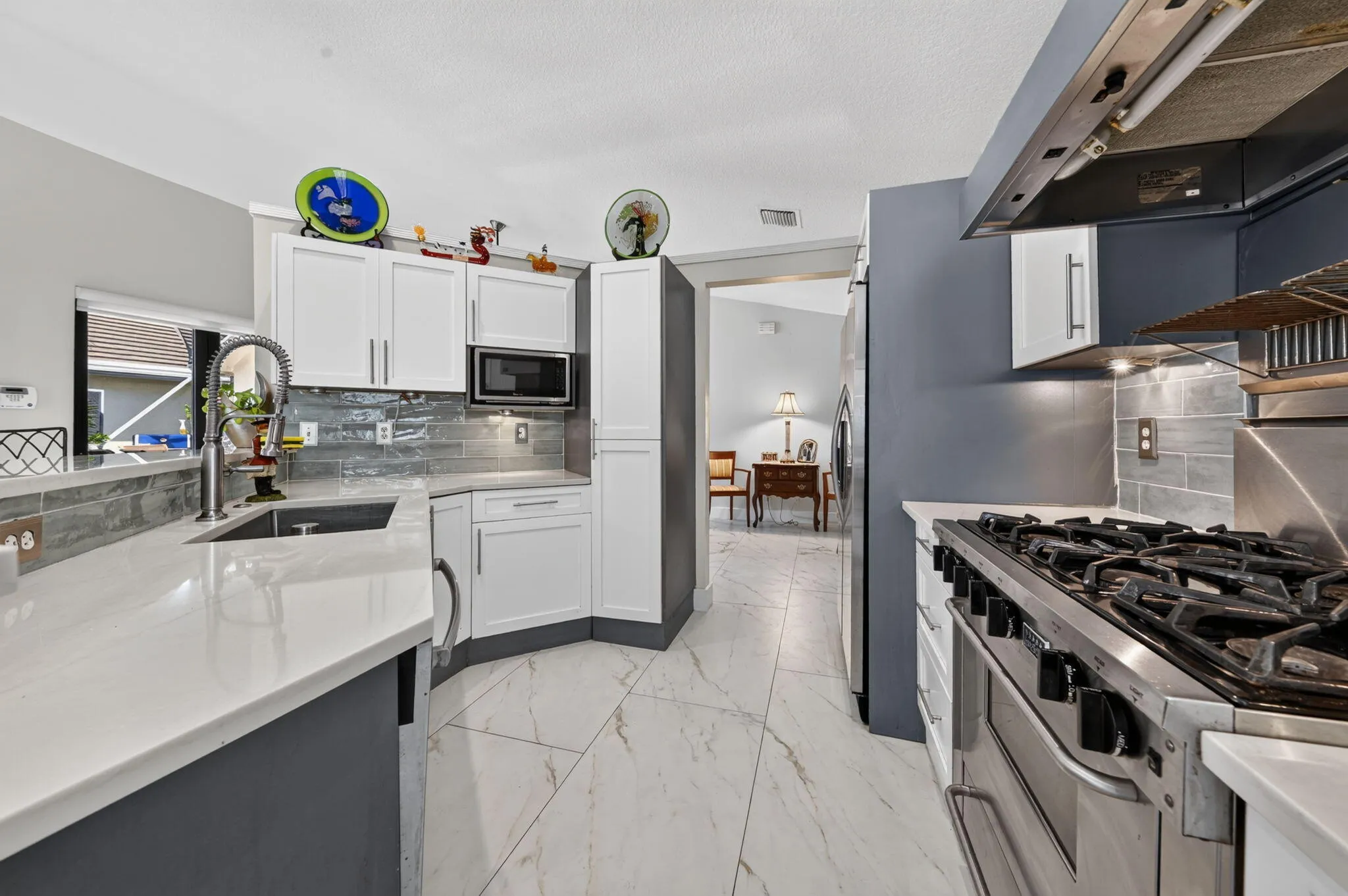 Quartz countertops coordinate with tile flooring, white with gray veining.