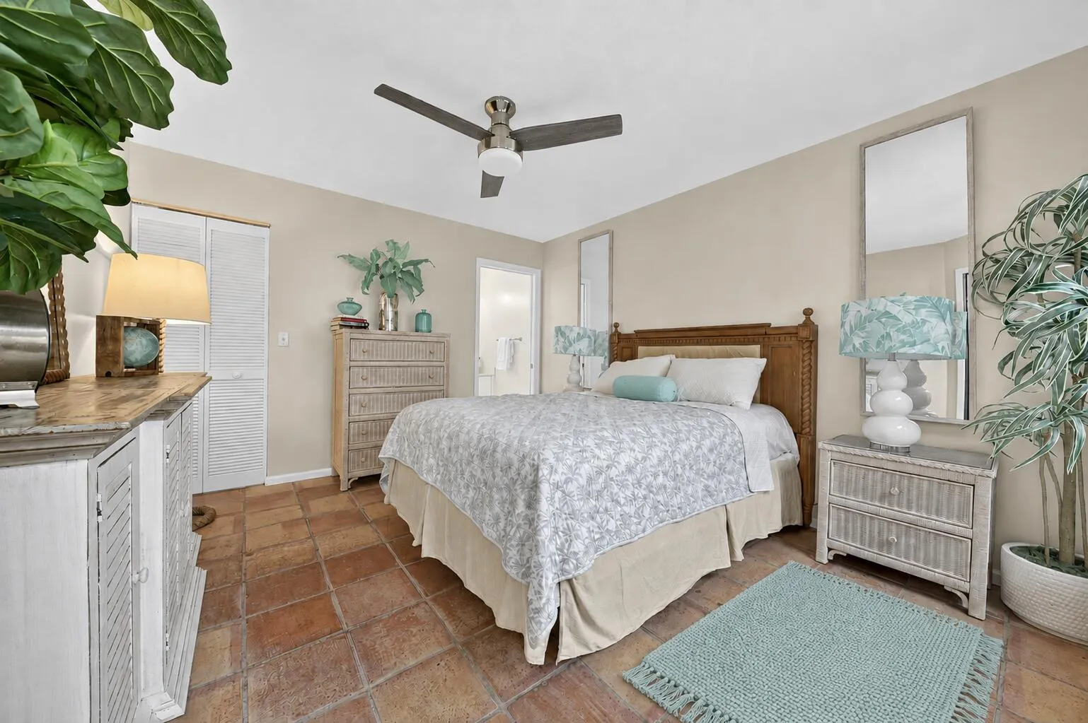 Terracotta tile flooring, ceiling fan with integrated lighting, and neutral wall tones