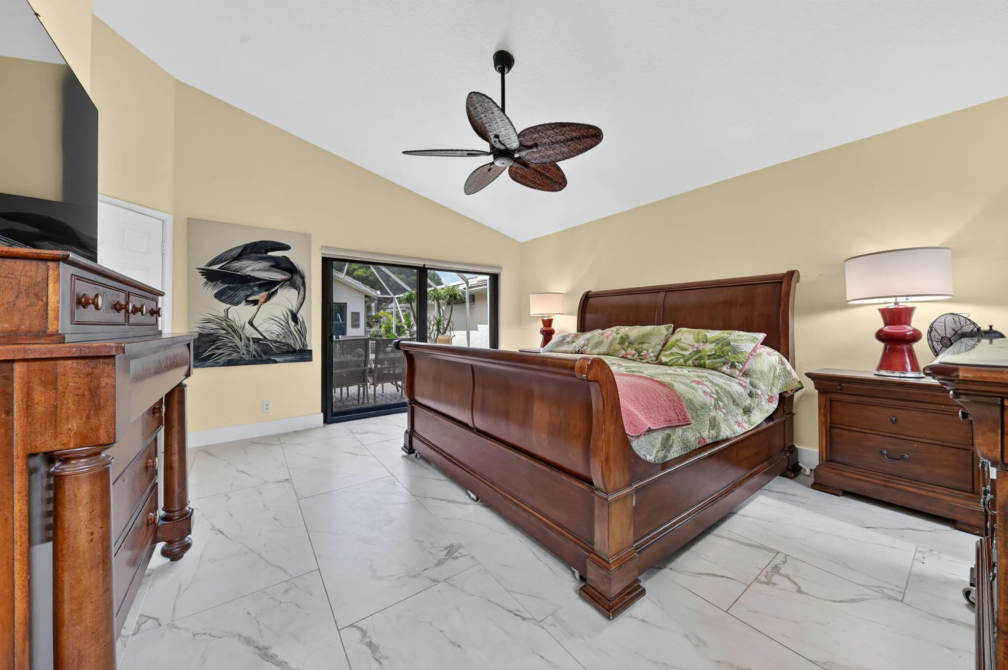 Large master overlooks courtyard through impact sliders. The new large format tile flooring flows throughout most living areas