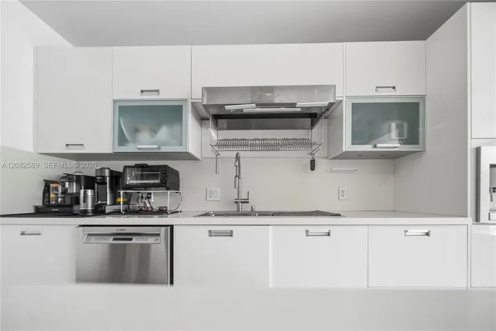 Sleek kitchen workspace featuring modern cabinetry, stainless-steel dishwasher, and contemporary sink area.