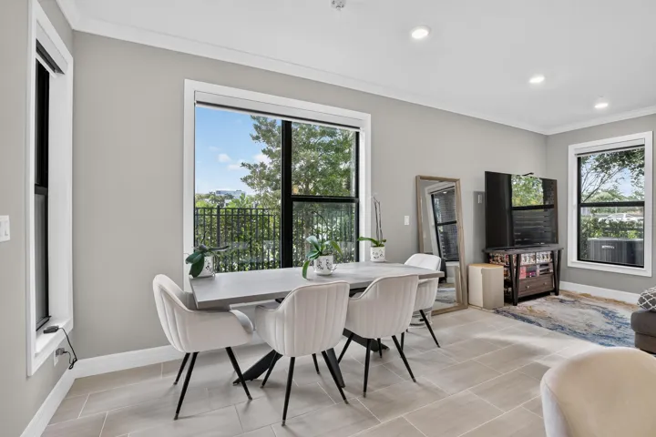 Recessed lighting, crown molding, white trim, and light-toned tile flooring
