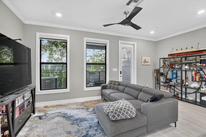 Recessed lighting illuminates the room, complemented by a modern ceiling fan